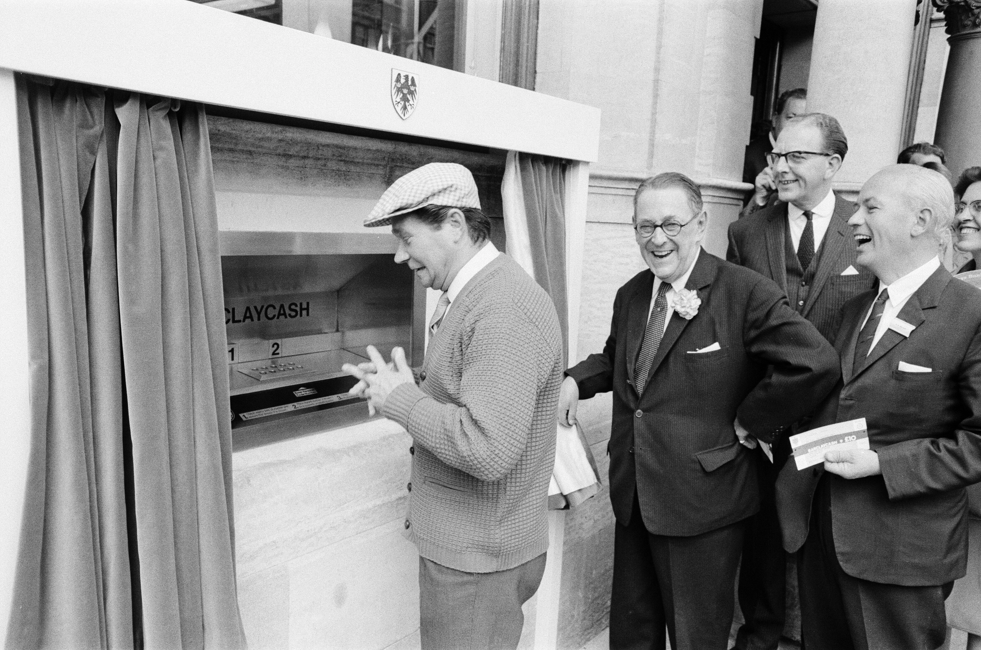 Comedian Reg Varney (pictured wearing a cap) became the first Londoner to withdraw money from a Barclaycash machine (1967). Photo: Getty Images